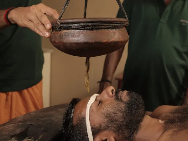 Shirodhara therapy - warm oil poured on forehead for stress relief and mental clarity